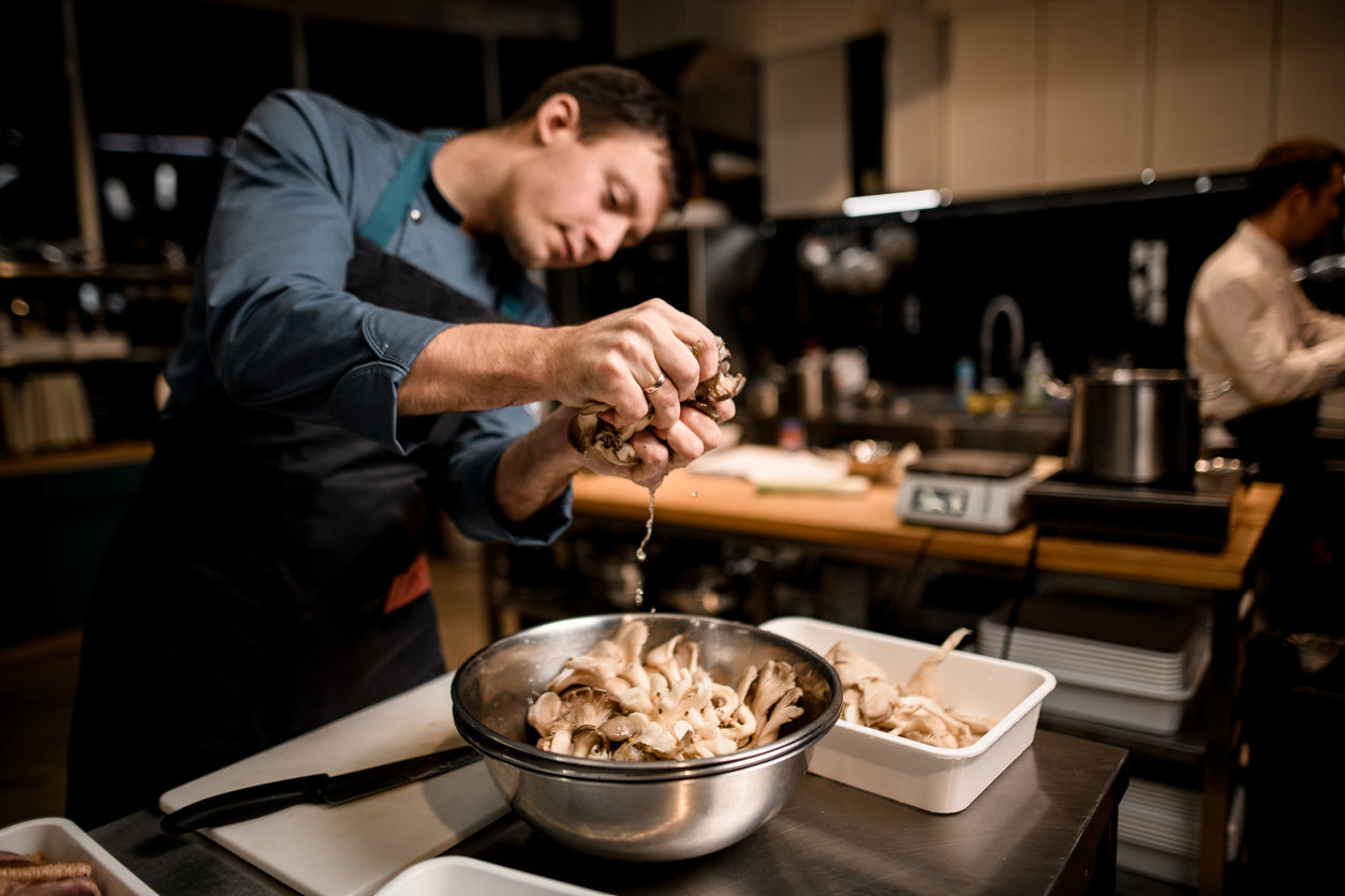 a man in a kitchen preparing food - buy wholesale mushrooms in Minnesota
